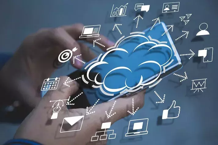 A person uses a smartphone with a cloud icon and various interconnected symbols, including a calendar, email, target, thumbs-up, and graphs, representing cloud IT services and technology integration.