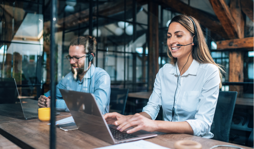 How IT Support Services Improve Employee Productivity 2 Woman and man working on helpdesk for IT support services company