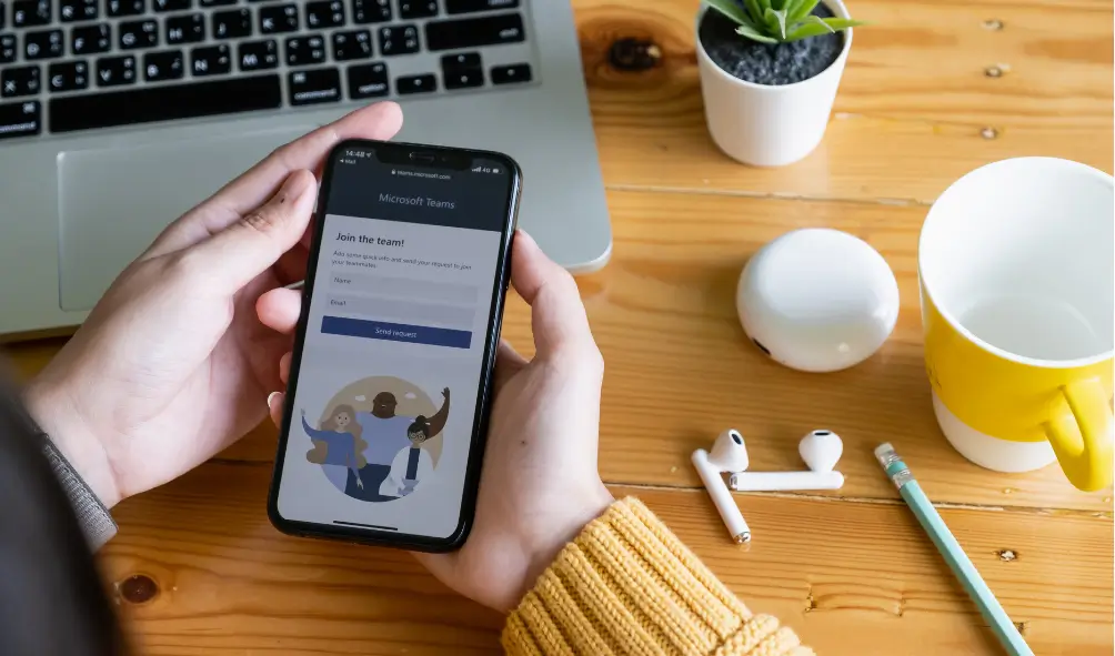 The Ultimate Guide to Microsoft Teams Phone Systems and Direct Routing 2 Person on mobile phone using Microsoft Teams phone system and Teams direct routing in workplace