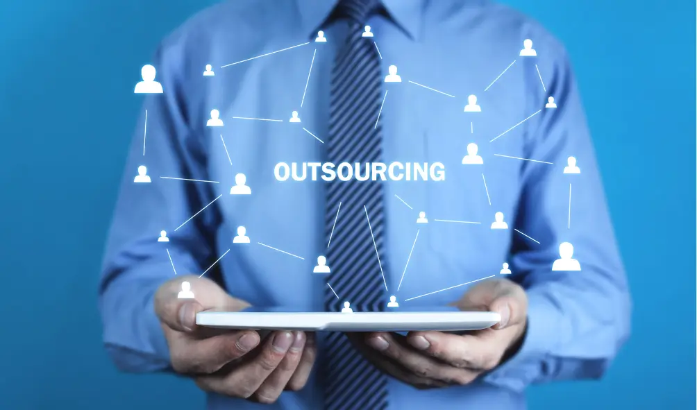 Top 10 Reasons Why You Should Outsource Your IT 2 Person in suit holding tablet with the word outsourcing shown symbolising outsource your IT
