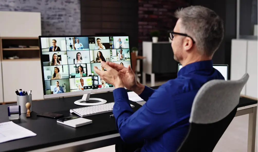 Azure Virtual Desktop: Enhancing Productivity for Remote Workers 2 Man working at desk on his computer accessing his azure virtual desktop to to a virtual meeting.