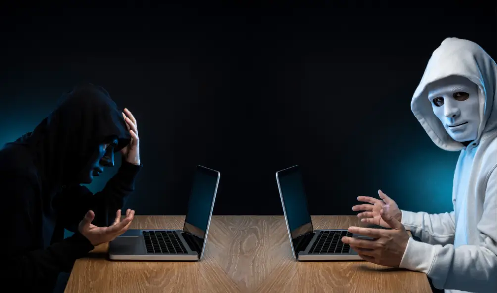 Red Team vs Blue Team in Cyber Security: A Comprehensive Guide 2 Two men with laptops, one part of red team and one part of blue team showing red v blue team in cyber security.